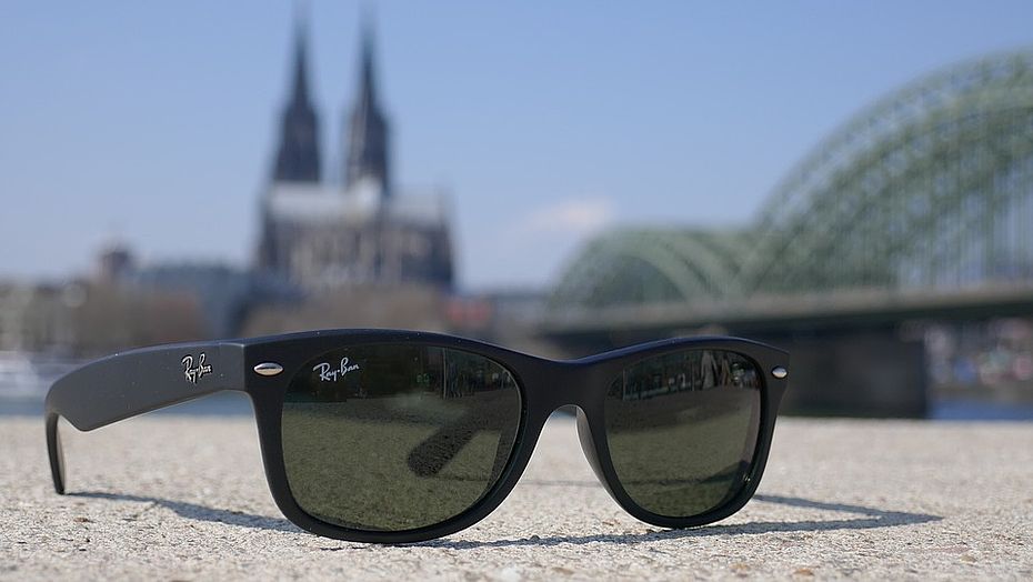 Sonnenbrille auf einem Stein, im Hintergrund der Rhein und der Kölner Dom