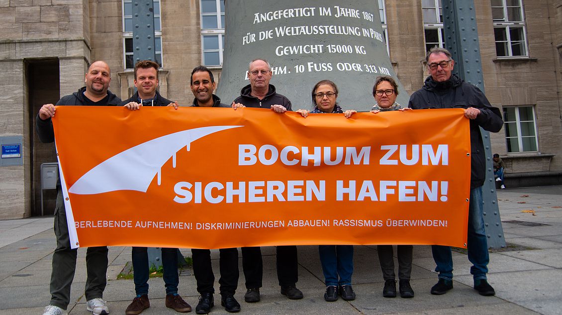 Sieben Personen halten ein Banner mit Aufschrift "Bochum zum sicheren Hafen!"